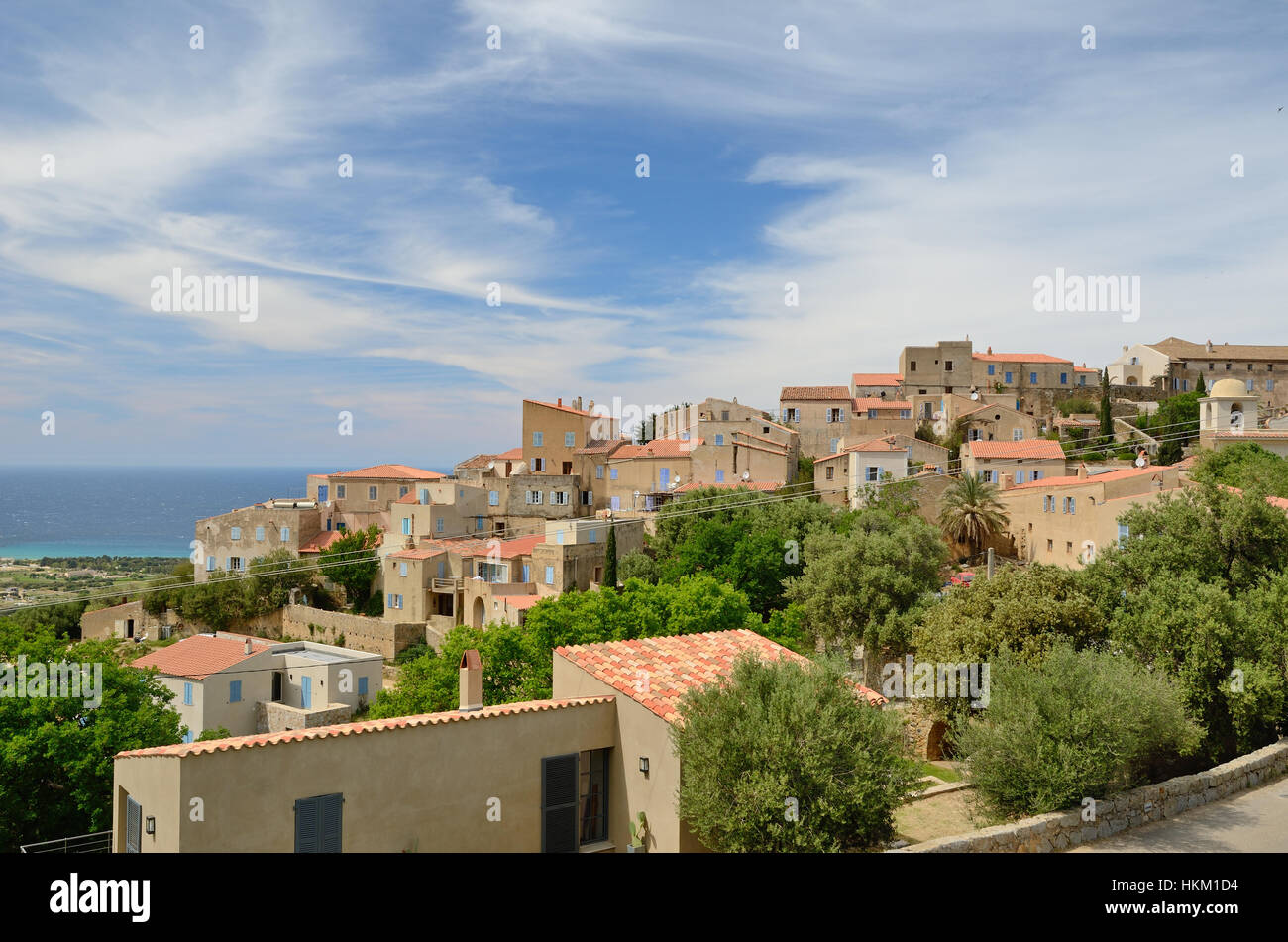Das alte Dorf Pigna thront am bewaldeten Berghang. Im Hintergrund ist das Mittelmeer. Stockfoto