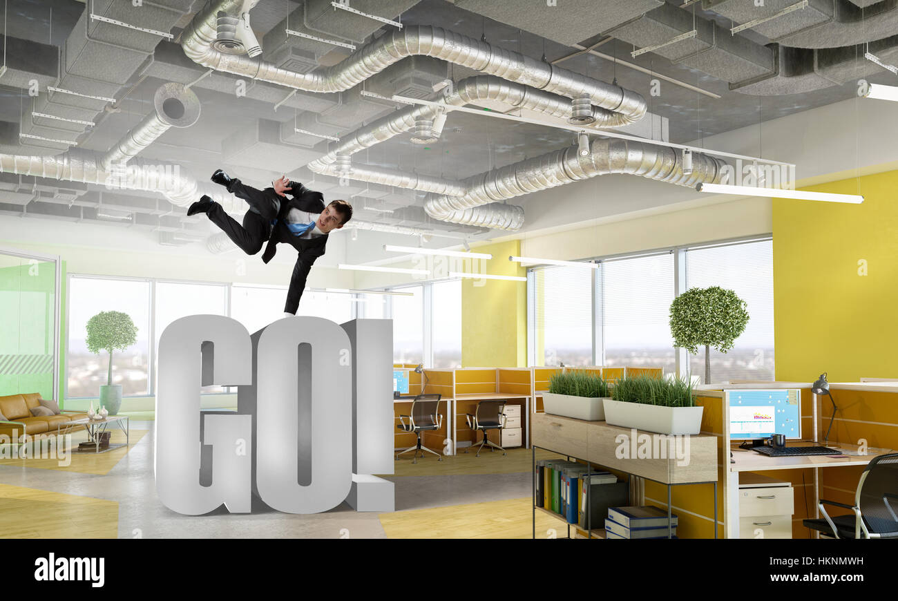 Fröhliche Jungunternehmer tanzen in seinem Büro. Mixed-media Stockfoto