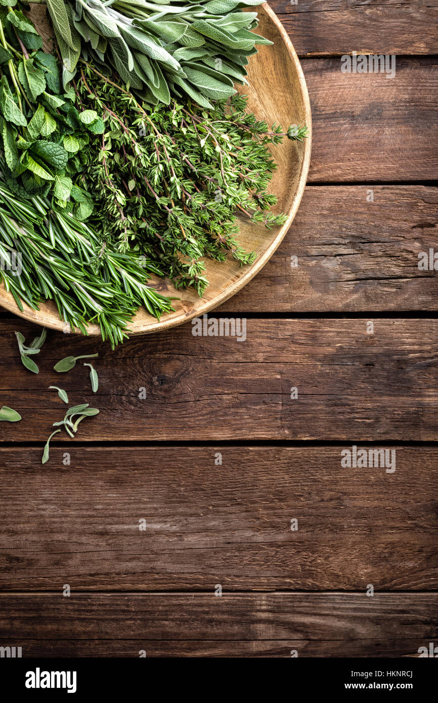 verschiedene frische Kräuter, Rosmarin, Thymian, Minze und Salbei auf hölzernen Hintergrund Stockfoto