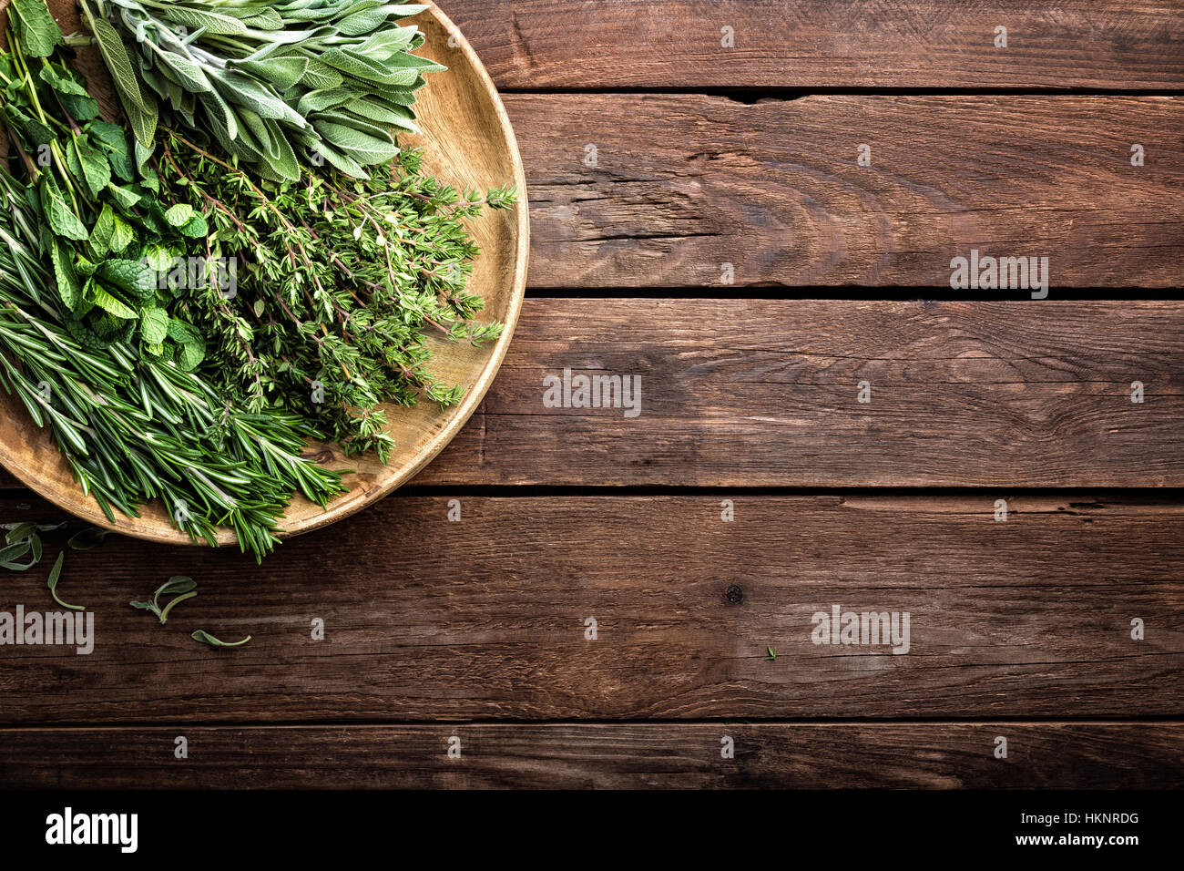 verschiedene frische Kräuter, Rosmarin, Thymian, Minze und Salbei auf hölzernen Hintergrund Stockfoto