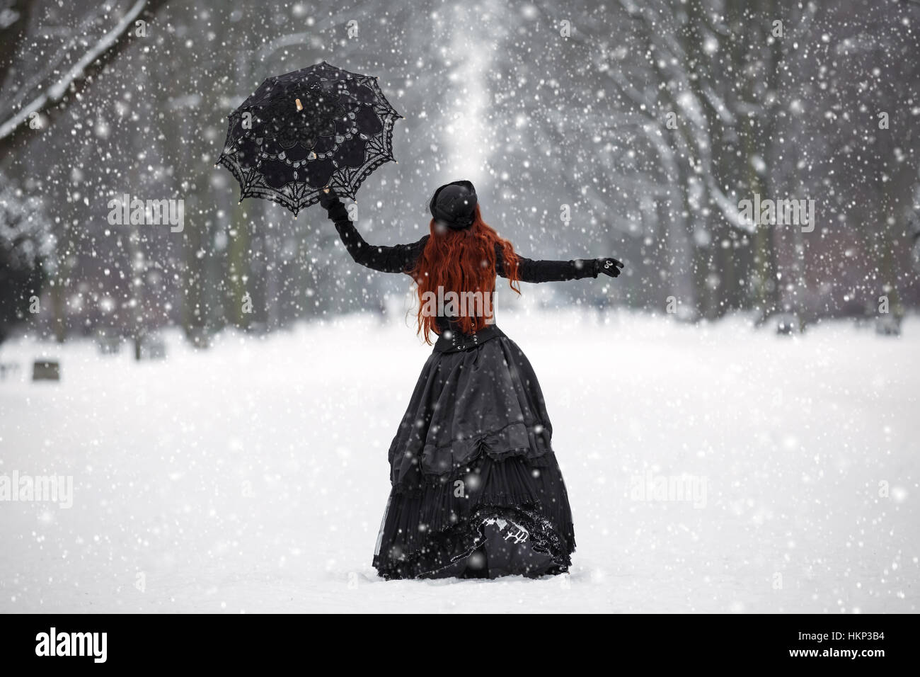 Geheimnisvolle rothaarige Frau im viktorianischen Kleid im Winter park Stockfoto