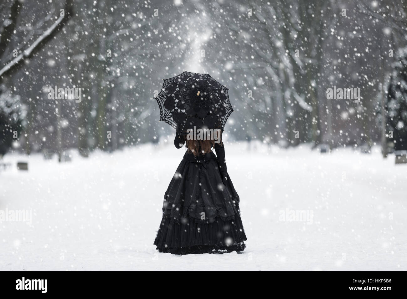 Geheimnisvolle einsame Frau im viktorianischen Kleid Abfahrt in die Ferne Stockfoto