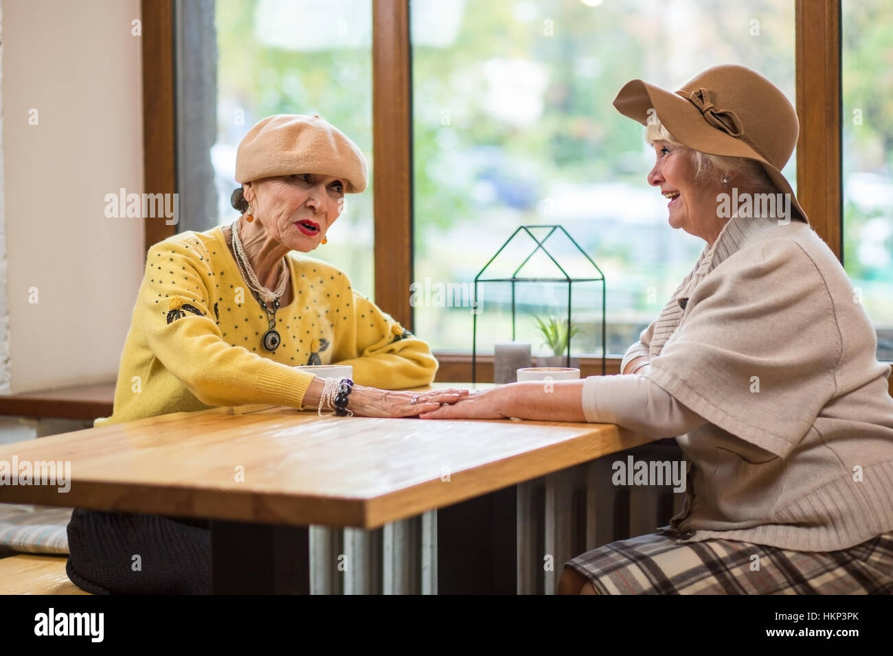 Ältere Damen und Café-Tisch. Stockfoto