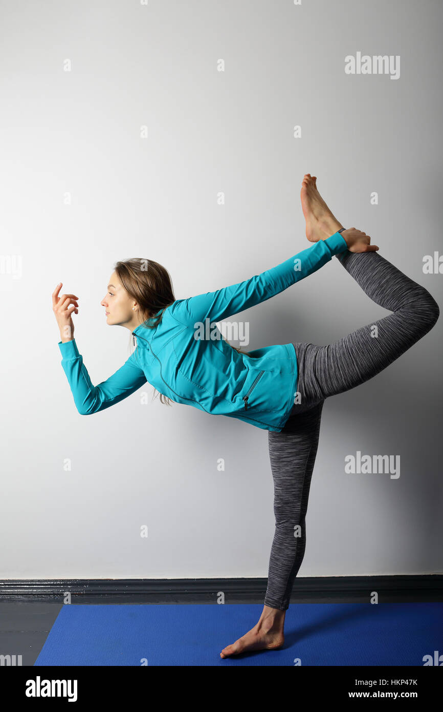 Junge Frau Yoga zu praktizieren, halten das Gleichgewicht auf einem Bein Stockfoto
