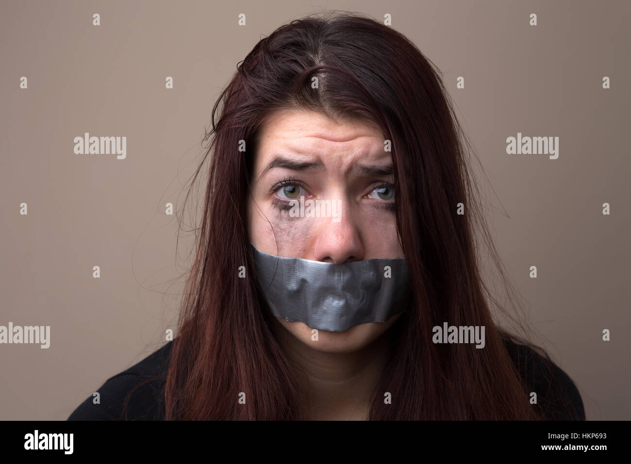 Verängstigte Frau als Geisel mit Klebeband Stockfoto