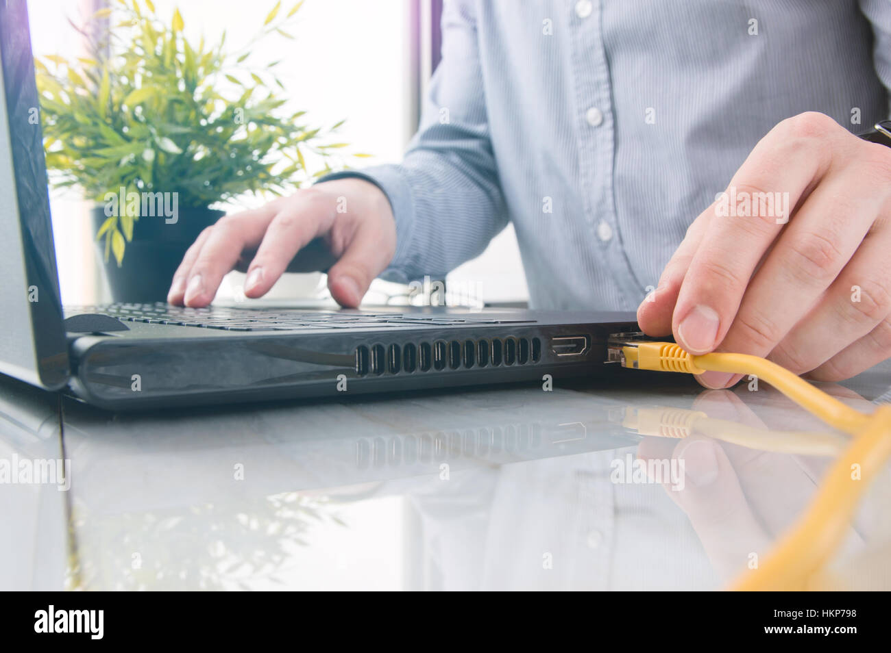 Mann ist gelbe LAN-Kabel an Laptop anschließen Stockfotografie - Alamy