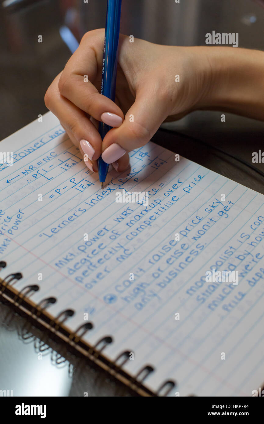 Eine Studentin schreibt am College Wirtschaftsnotizen Stockfoto
