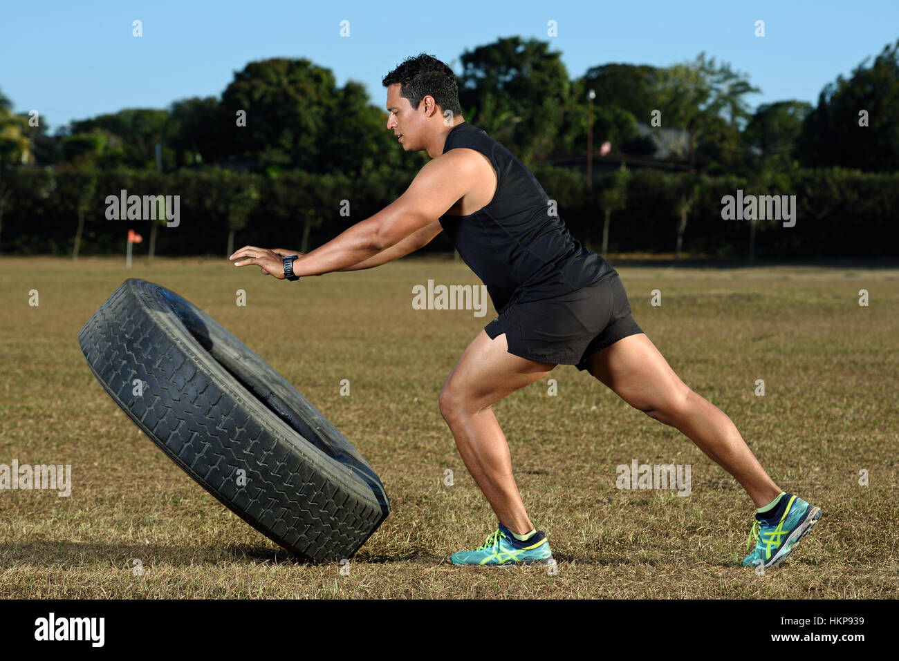 Sport Kerl spiegeln große Reifen auf Rasen-Stadion Stockfoto