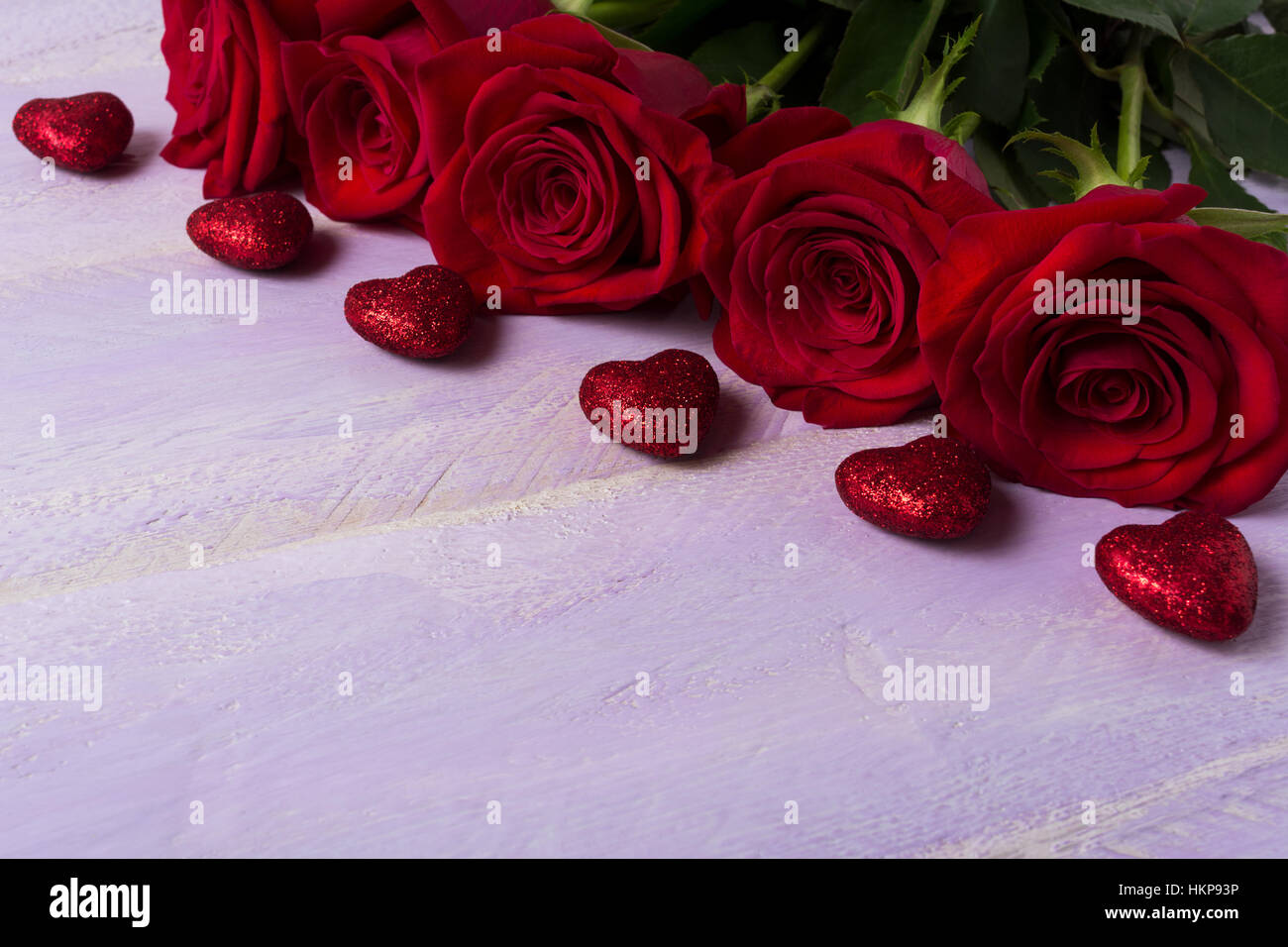 Burgunder Rosen und roten Glitzer Herzen auf lila Hintergrund. St. Valentin-Tag-Grußkarte. Elegante Hochzeit Tag Einladung. Kopieren Sie Raum. Stockfoto