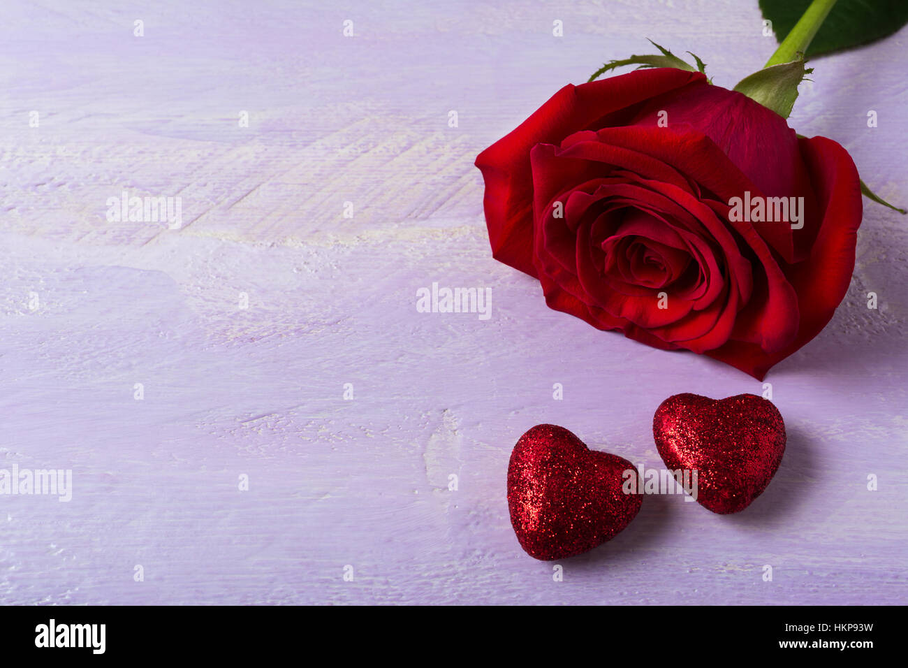 Ein Burgunder Rose und rot glitter Herzen. St. Valentines Day Background. Elegante Hochzeit Tag Grußkarte oder Einladung. Kopieren Sie Raum. Stockfoto