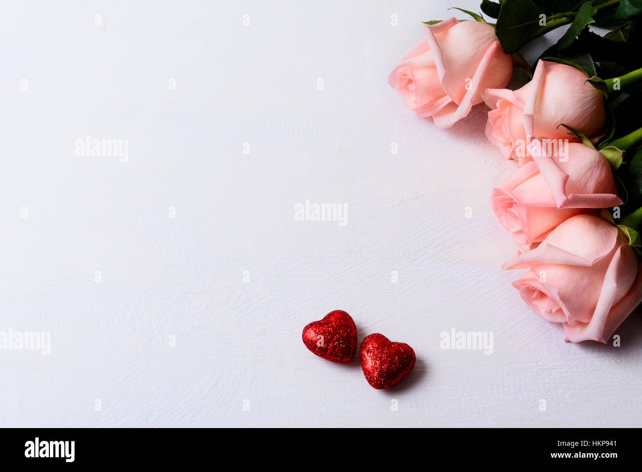 Blass rosa Rosen und roten Glitzer Herzen. St. Valentines Day Background. Elegante Hochzeit Tag Grußkarte oder Einladung. Kopieren Sie Raum. Stockfoto