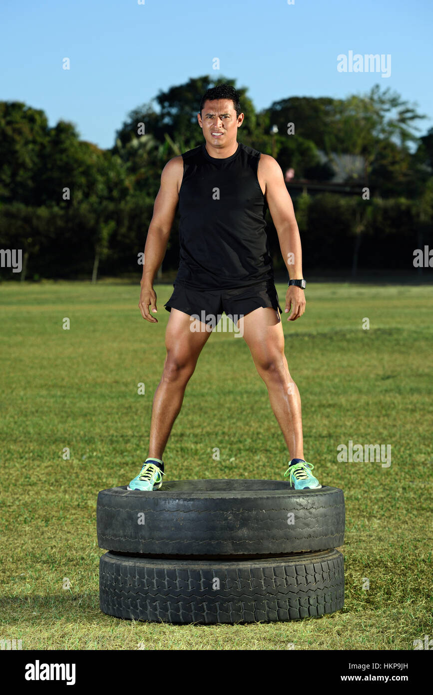 Sport Mann stehen auf Reifen auf grünen Rasen park Stockfoto