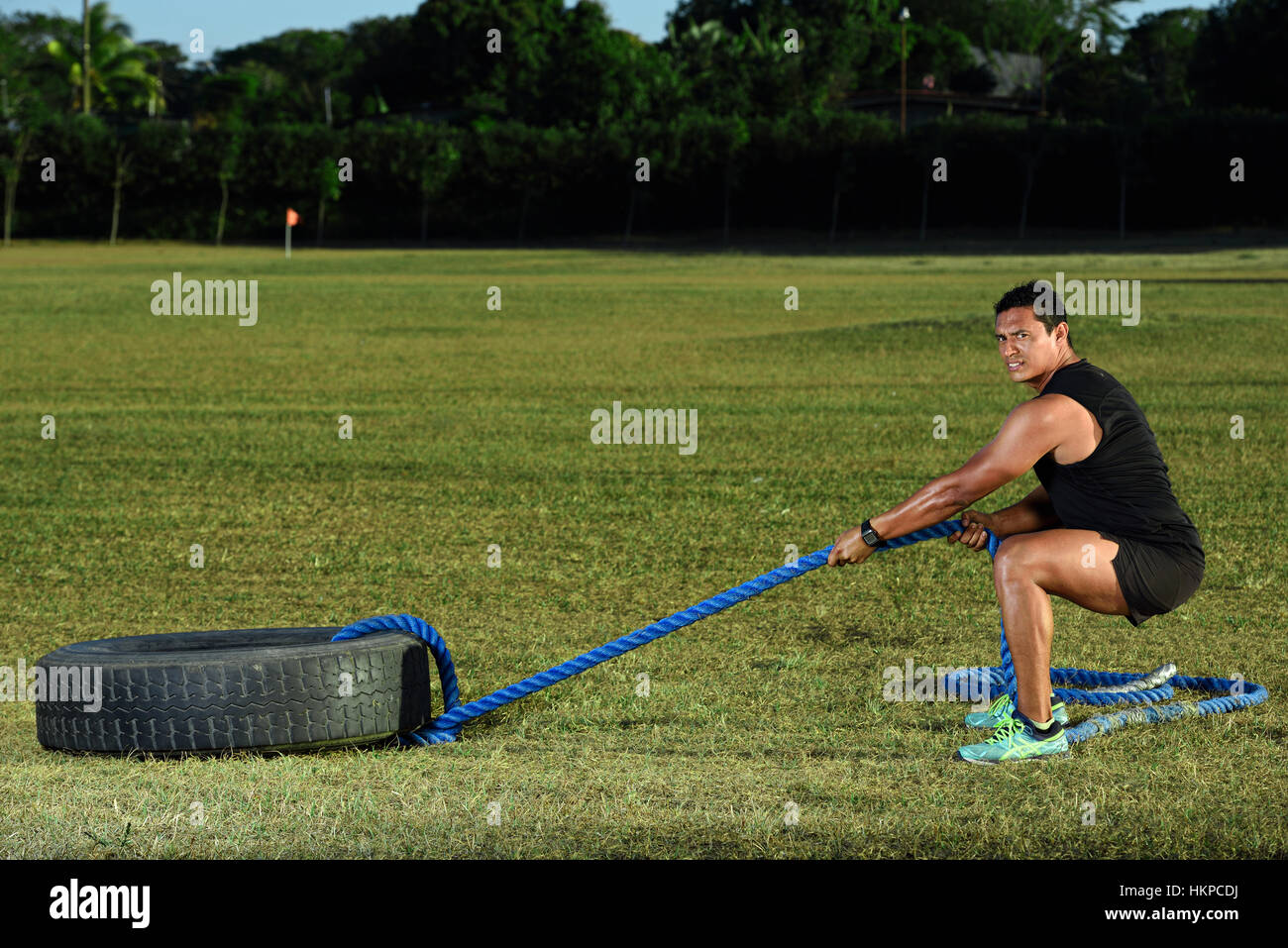 Sport-Mann-Training mit Reifen auf grünen Rasen park Stockfoto