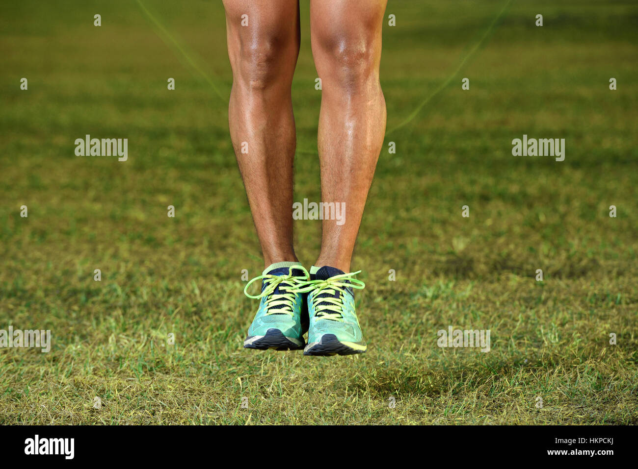 Nahaufnahme eines Füßen Mann Seilspringen auf dem grünen Rasen Stockfoto