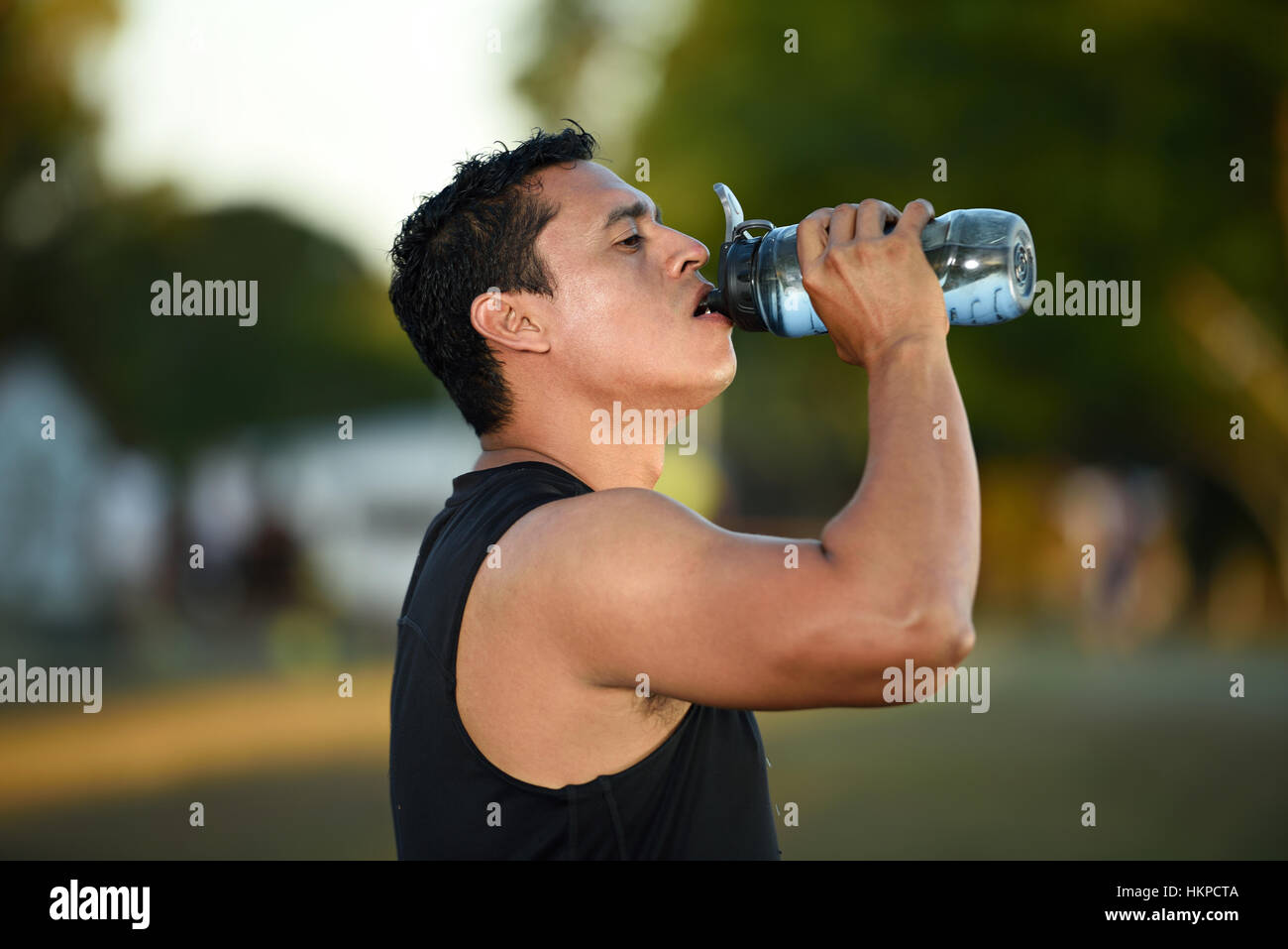Sport Mann Trinkwasser nach dem Training im park Stockfoto