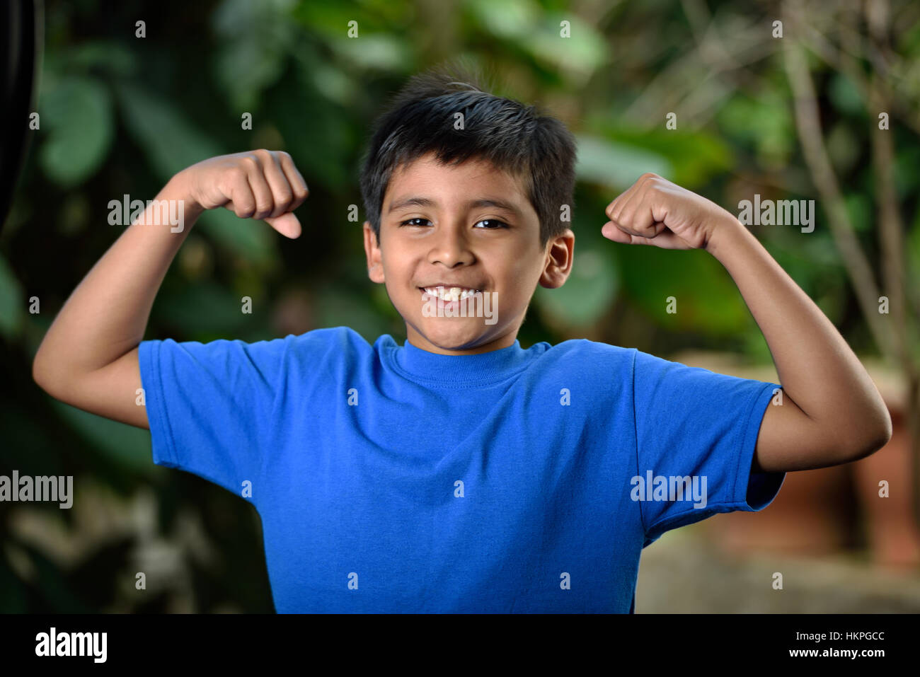 Junge Latino zeigen Muskeln in der grünen Natur Stockfoto
