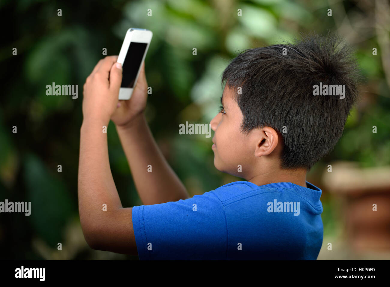 Junge mit Smartphone Aufnahme Fotos im park Stockfoto