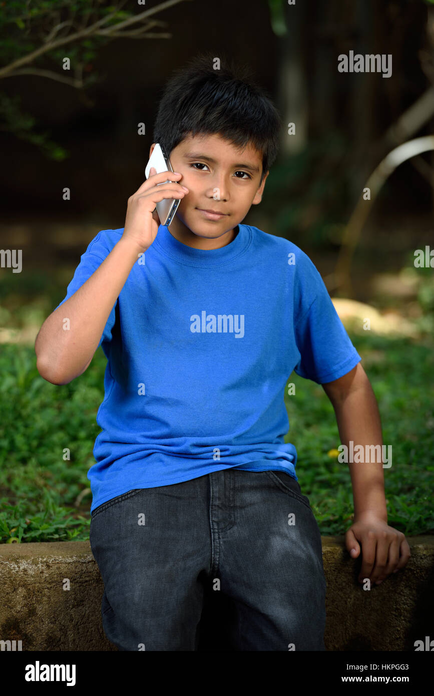 kleiner Junge sprechen im Telefon im grünen park Stockfoto