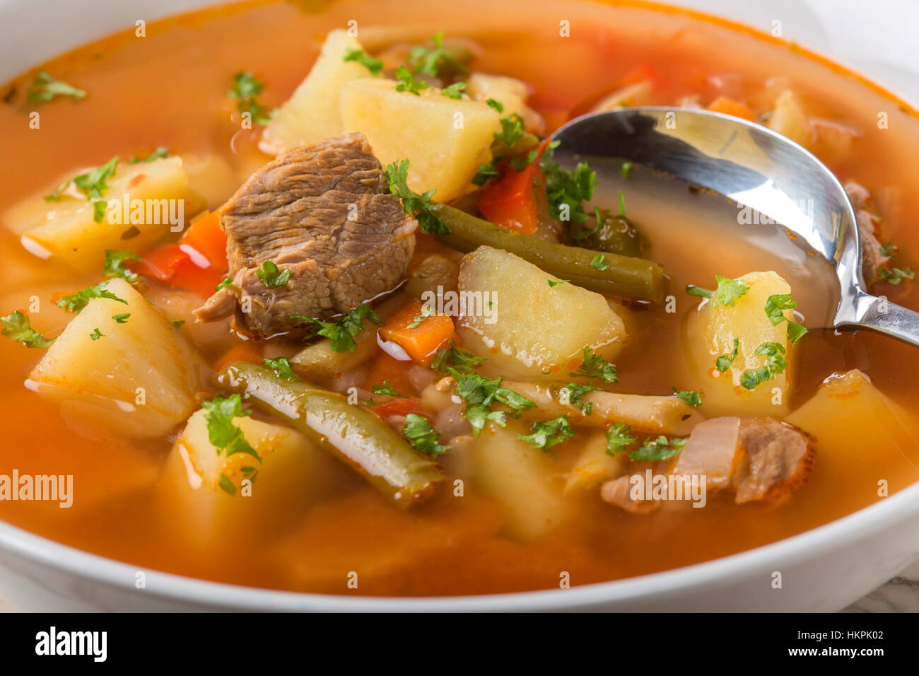 Nahaufnahme von Gemüse Rindfleisch Suppe mit Löffel Stockfoto
