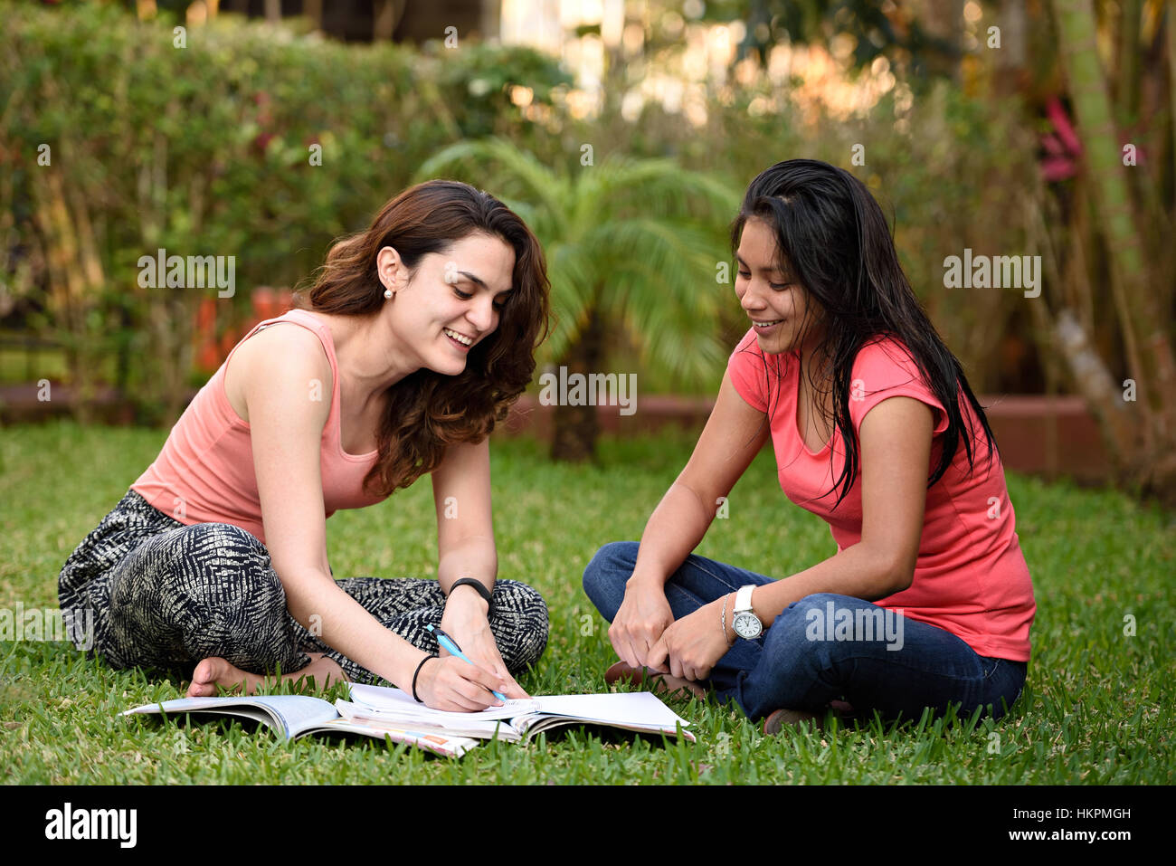 Latino Mädchen lernen Sprache sitzen im grünen Rasen im park Stockfoto