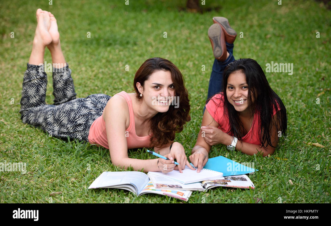 Mädchen mit Lächeln lernen lag auf dem grünen Rasen Stockfoto