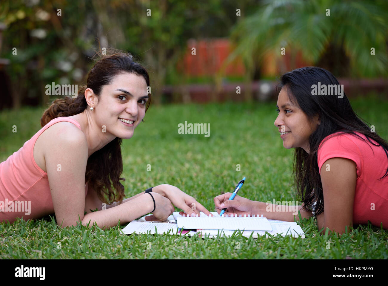 zwei Mädchen Lernsprache Verlegung auf dem Rasen im park Stockfoto