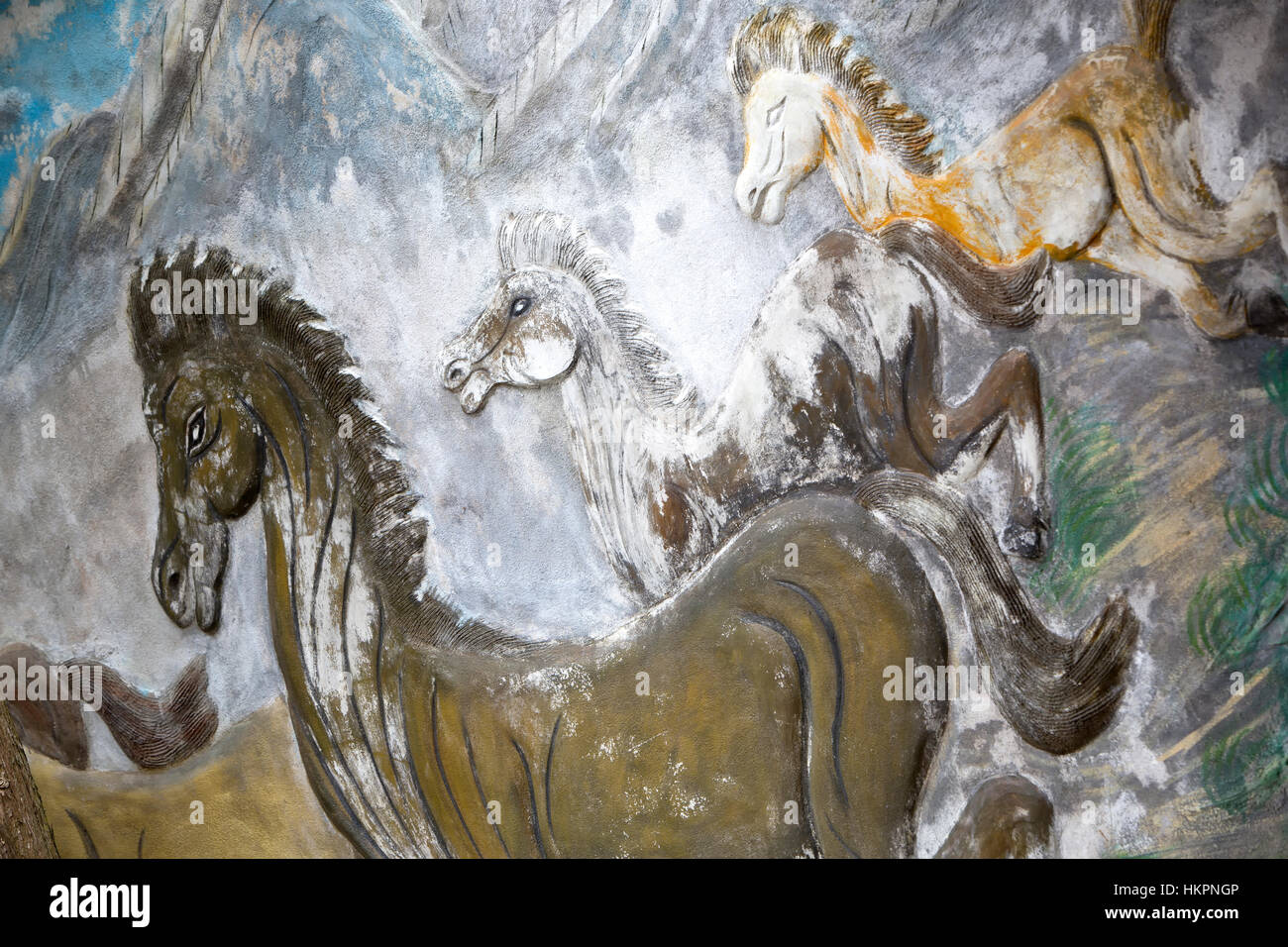 Gemälde von galoppierenden Pferden, Bergseite im Hintergrund. Stockfoto