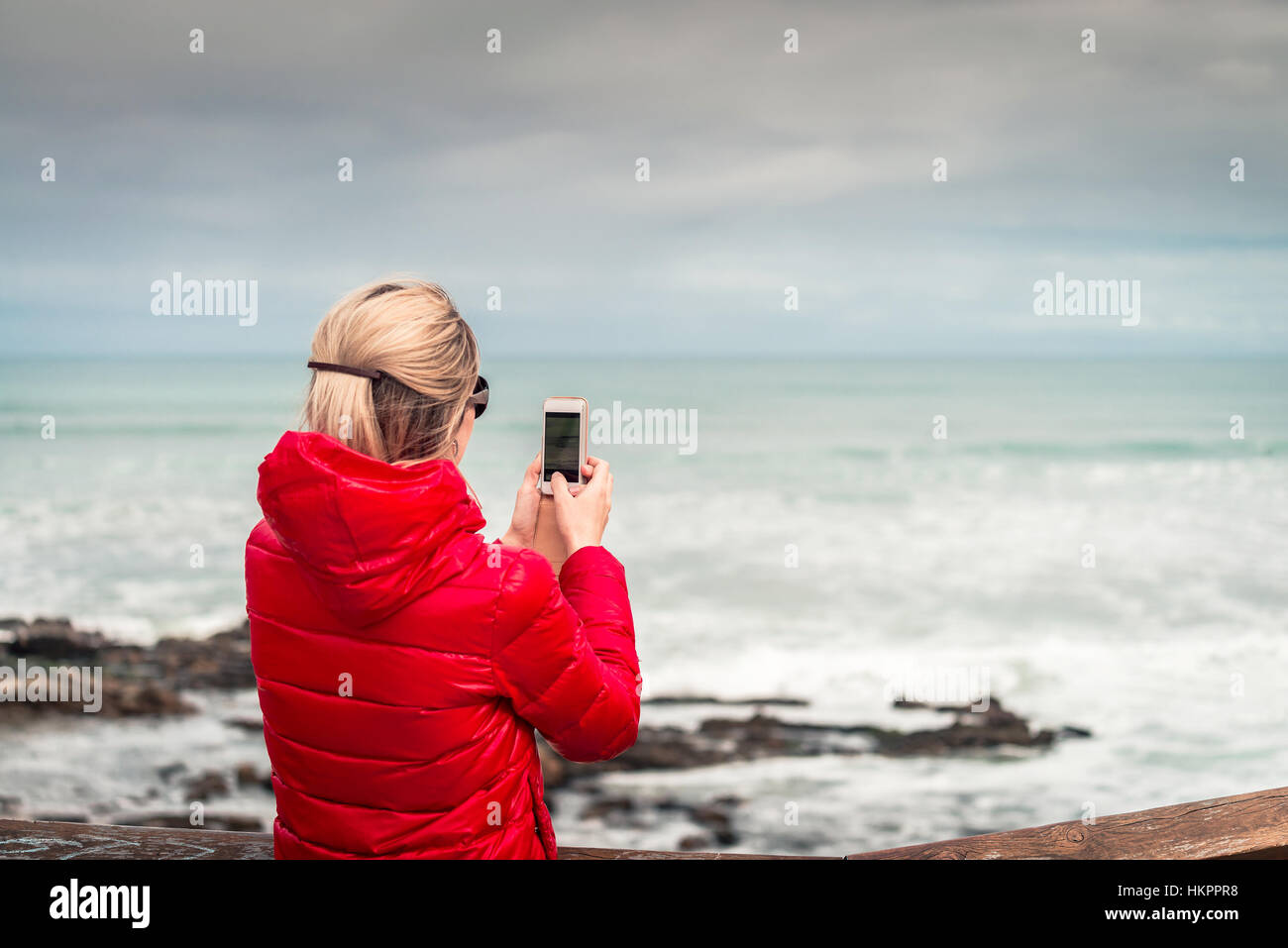 Frau, die das Fotografieren mit Handy der Blick auf das Meer, South Australia Stockfoto