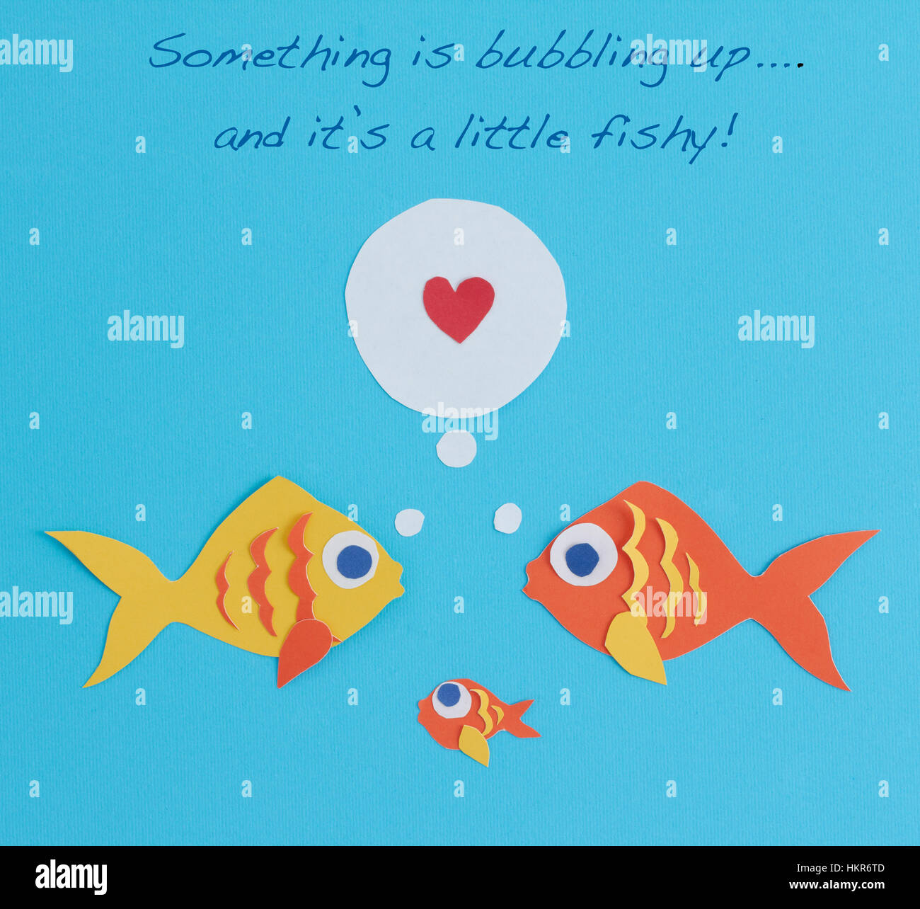 Ein paar Fische hat einen Neuzugang in der Familie: ein Babyfisch!  Die Worte sind "etwas sprudeln ist und es ist ein wenig faul" darüber geschrieben. Stockfoto