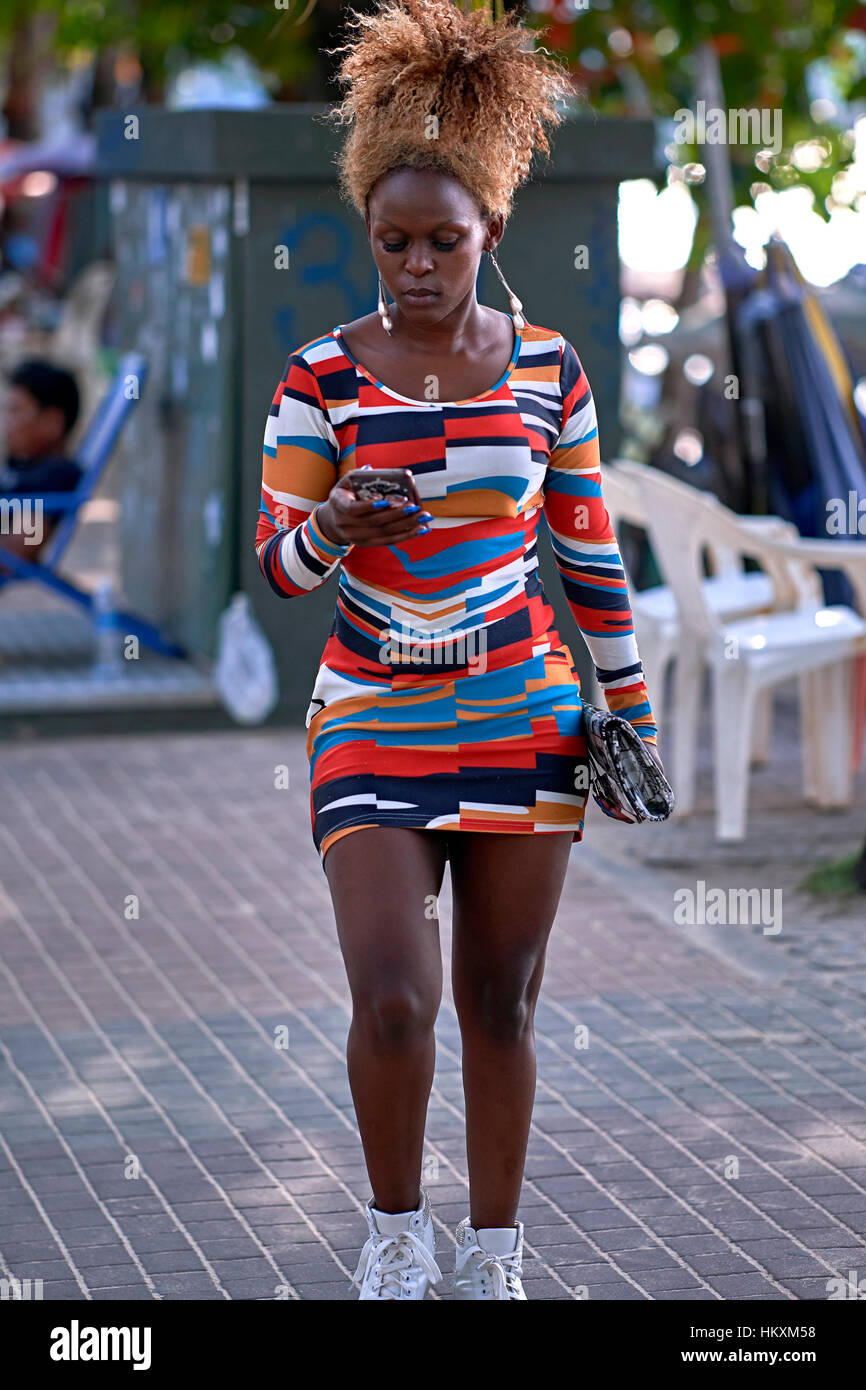 Bunte Kleidung. Schöne junge afrikanische Frau trägt eine markante mehrfarbige Kleid und Sport eine gebunden Afro Karibik krauses Frisur. Stockfoto