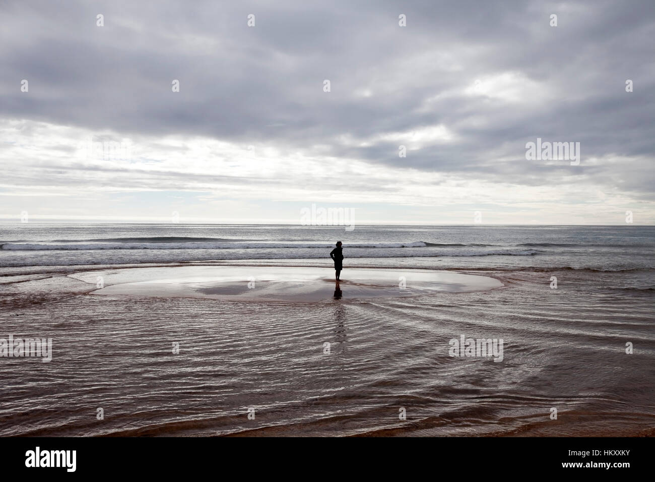 Mensch auf der kleinen Insel während der Flut an Rauðasandur, Westfjorde, Island Stockfoto