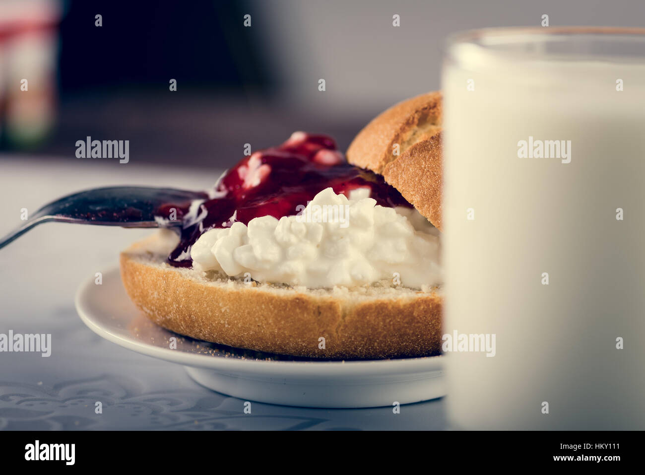 Glas Milch, frische leckere Sandwich machen Schnitt Roll, Quark und Marmelade. Hautnah. Exemplar Stockfoto