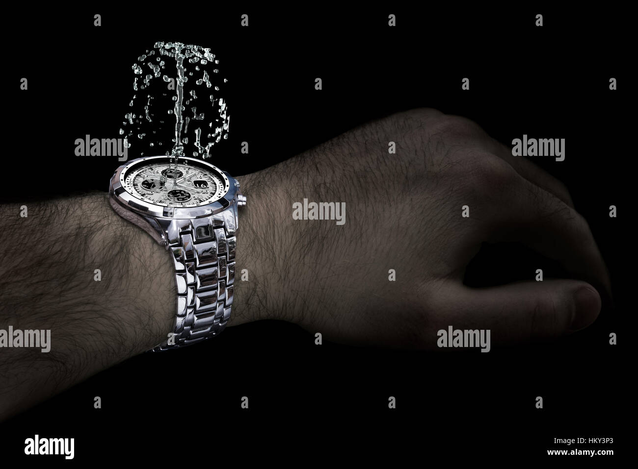 Silberne Uhr mit Brunnen am Handgelenk des Menschen. Isoliert auf dem schwarzen Hintergrund. Stockfoto