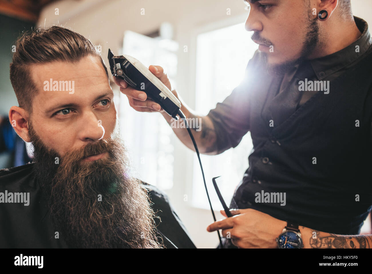 Junger Mann immer Haarschnitt beim Friseur. Friseur Haare schneiden des Clients im Friseurladen. Stockfoto