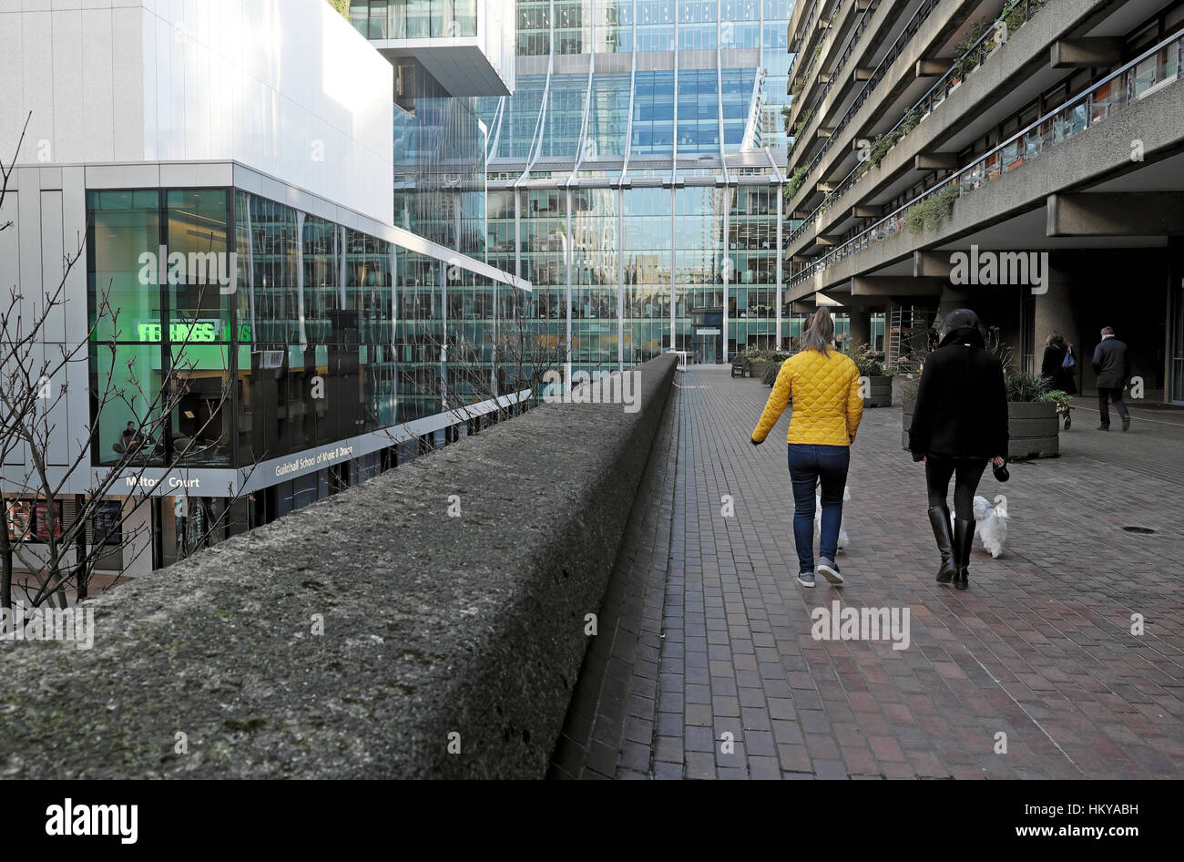 Zwei Frauen gehen Hunde außerhalb Bürogebäude im Barbican in der City of London, UK KATHY DEWITT Stockfoto