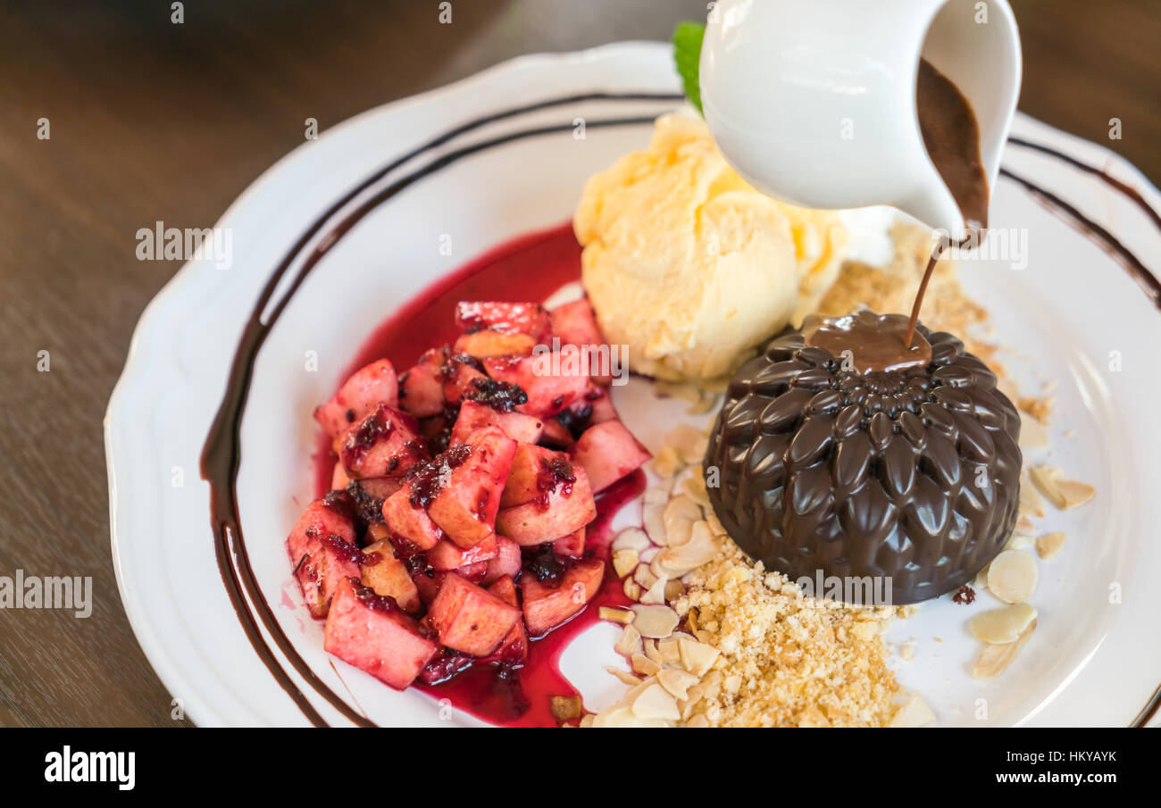 Schokoladenkuchen mit Früchten Pfirsich, schwarze Johannisbeere, Heidelbeere, Apfel, Eis Stockfoto