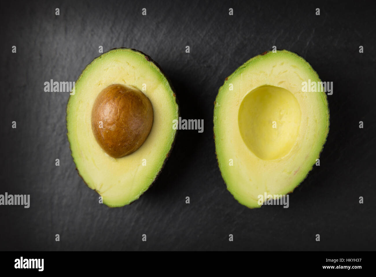 Halbierte Avocado Frucht auf dunklem Hintergrund Stockfoto