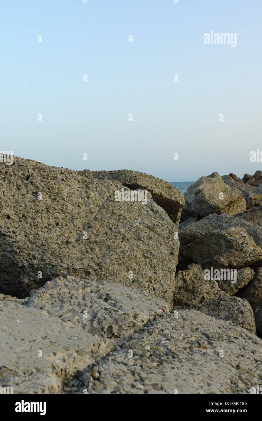 großen Steinen am Strand im Licht der untergehenden Sonne liegen Stockfoto