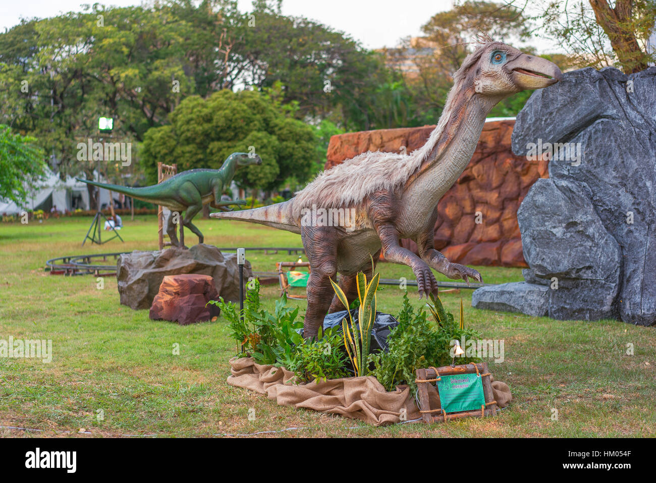 Dinosaurier im Park mit grünem Rasen und Bäumen Stockfoto
