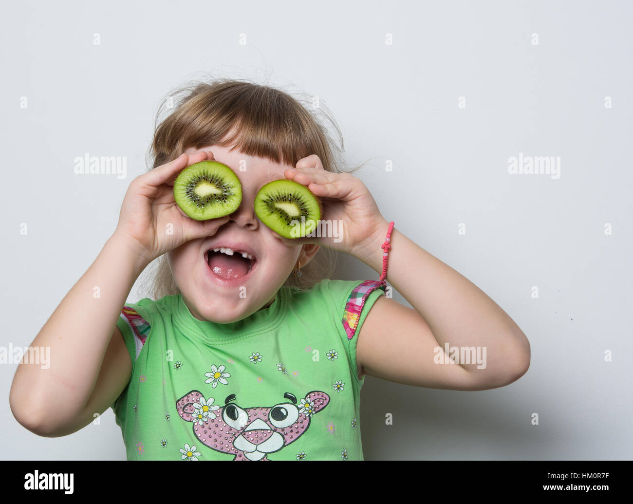 kleine Mädchen spielen mit kiwi Stockfoto