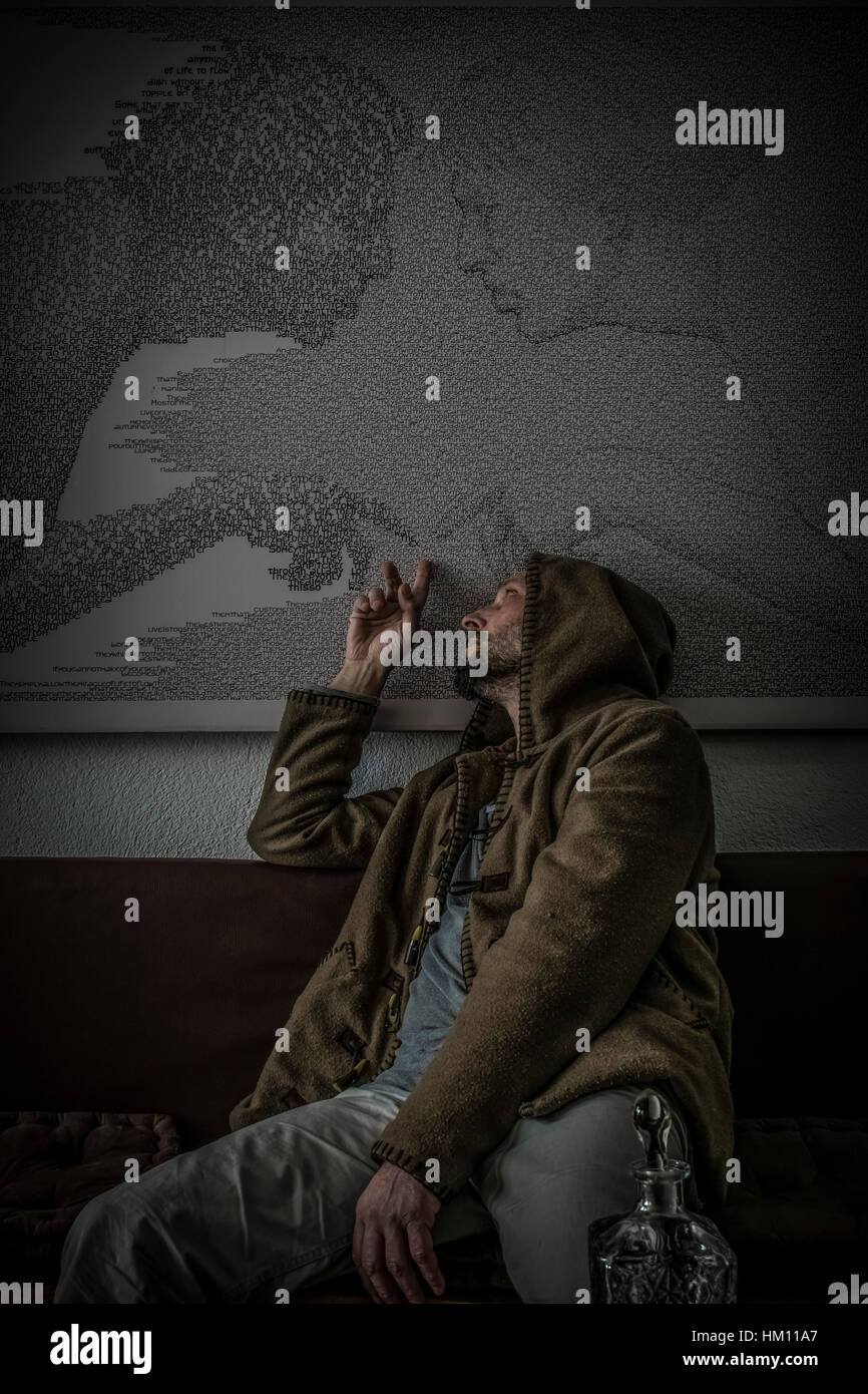 Ein depressiver Mann in einer Kapuze mit einer leeren gravierten Glasflasche mit Alkohol sitzt, zurückblickend und zeigt auf seine Vergangenheit. Stockfoto