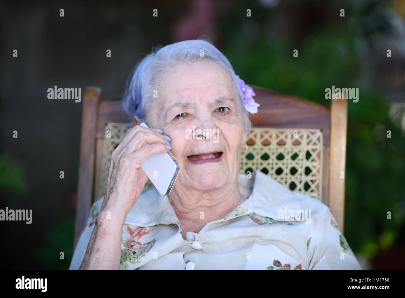 Oma sprechen und Lächeln am Telefon Stockfoto