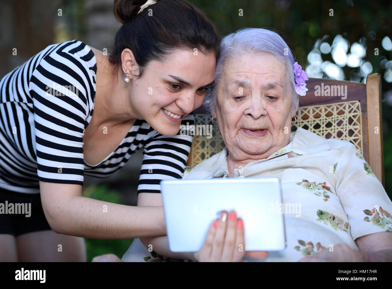 lächelnde Mädchen und Oma Tablet halten und schauen Sie in Stockfoto