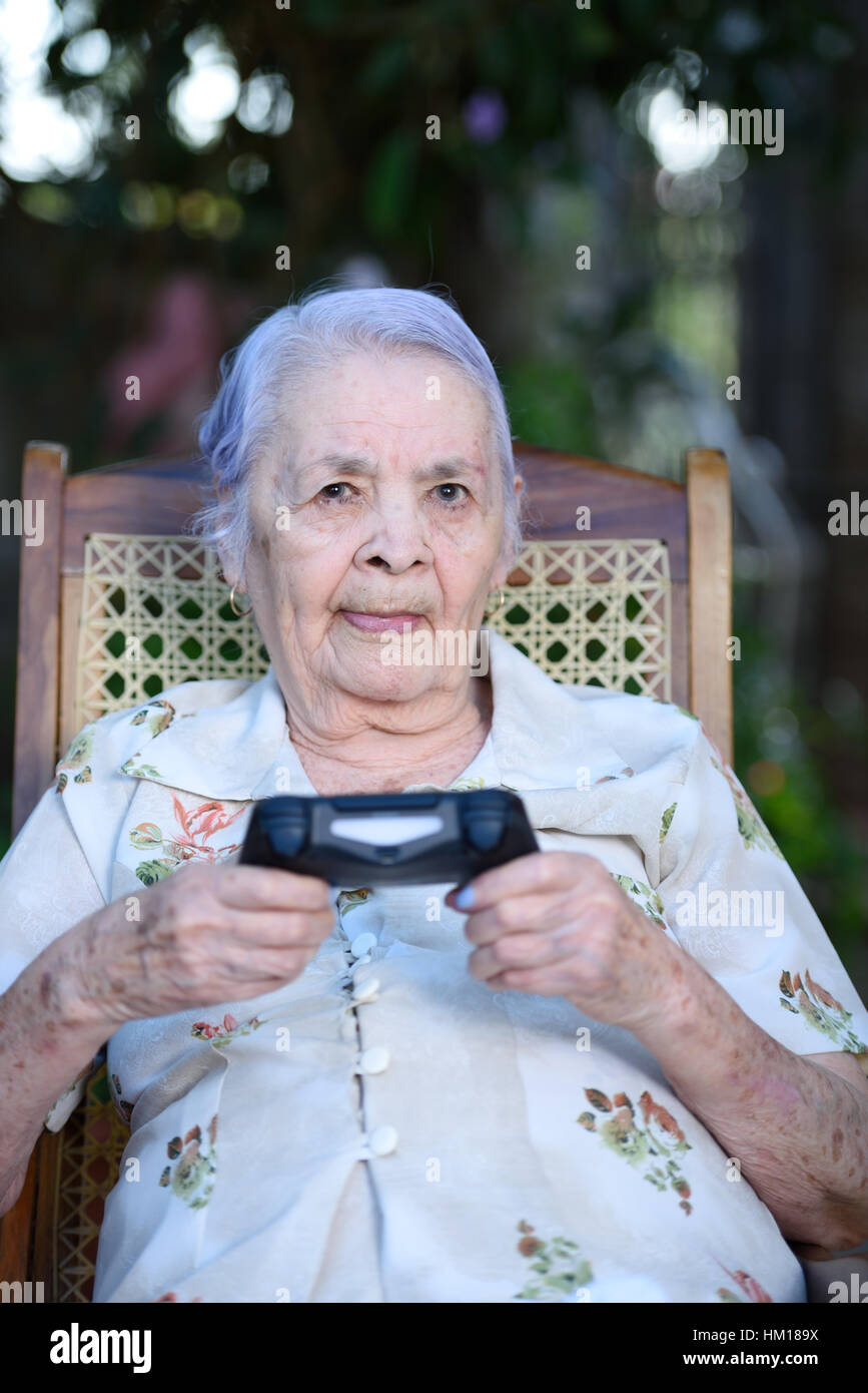 Oma hielt Joystick und Videospiele im Park spielen Stockfoto