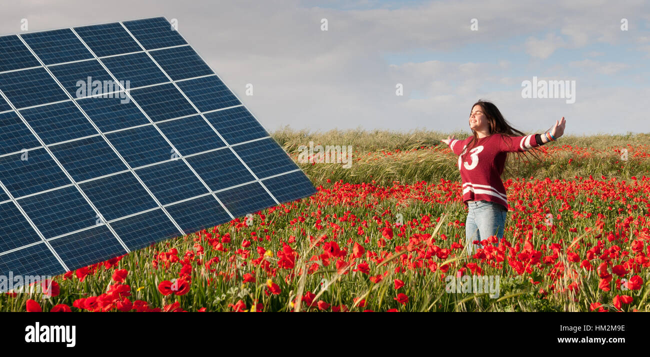 Solar Energie Energieleiste auf einem Feld mit roten Mohn Blumen und ein junges Mädchen springen zufrieden mit Freude für die Umwelt.  Konzept der erneuerbaren Stockfoto