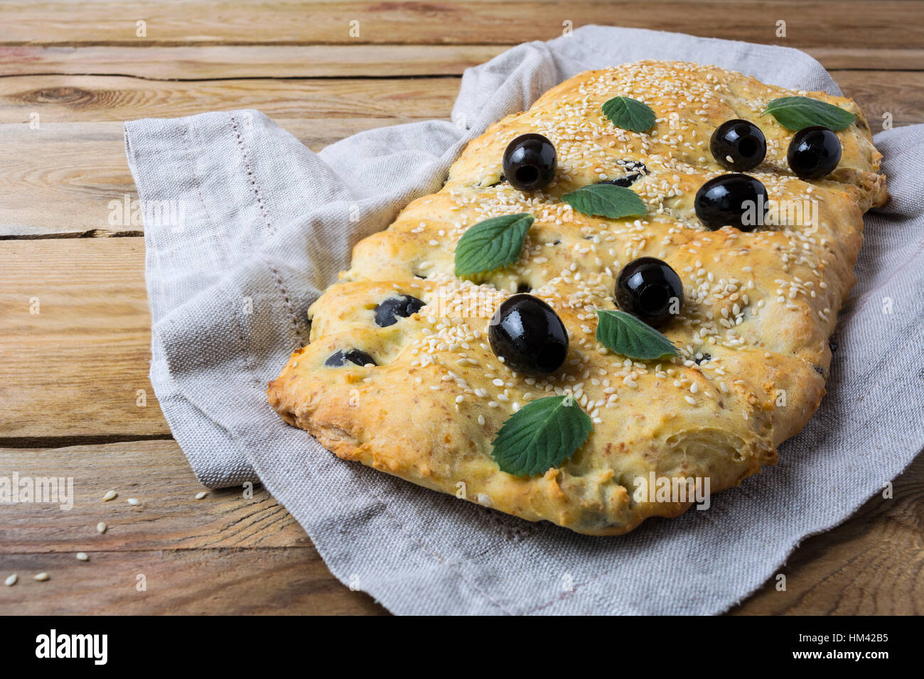 Italienisches Brot Focaccia mit Oliven. Hausgemachte traditionelle Brot auf dem rustikalen Tisch. Stockfoto