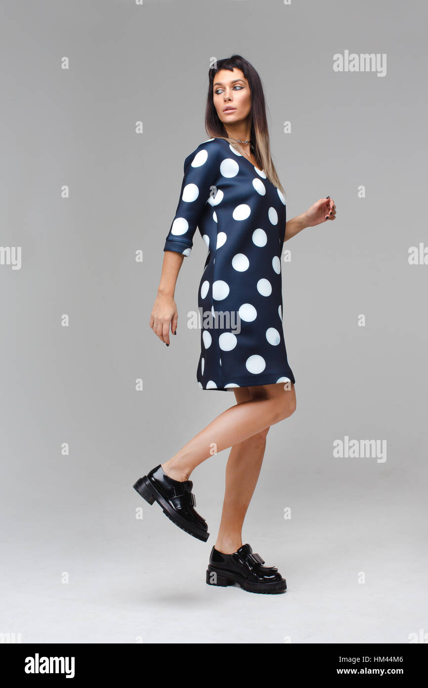 Modell im blauen Kleid mit Polka Dots, Schritte Stockfoto