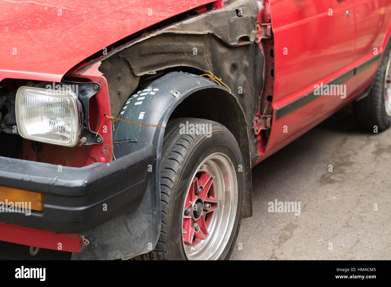 Beschädigte alte rote Auto ohne Körperteile Stockfoto