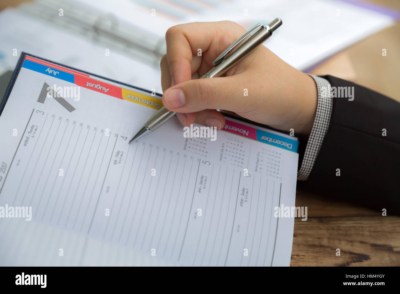 Geschäftsleute, die während der Sitzung auf Kalender-Dokument zeigen Stockfoto