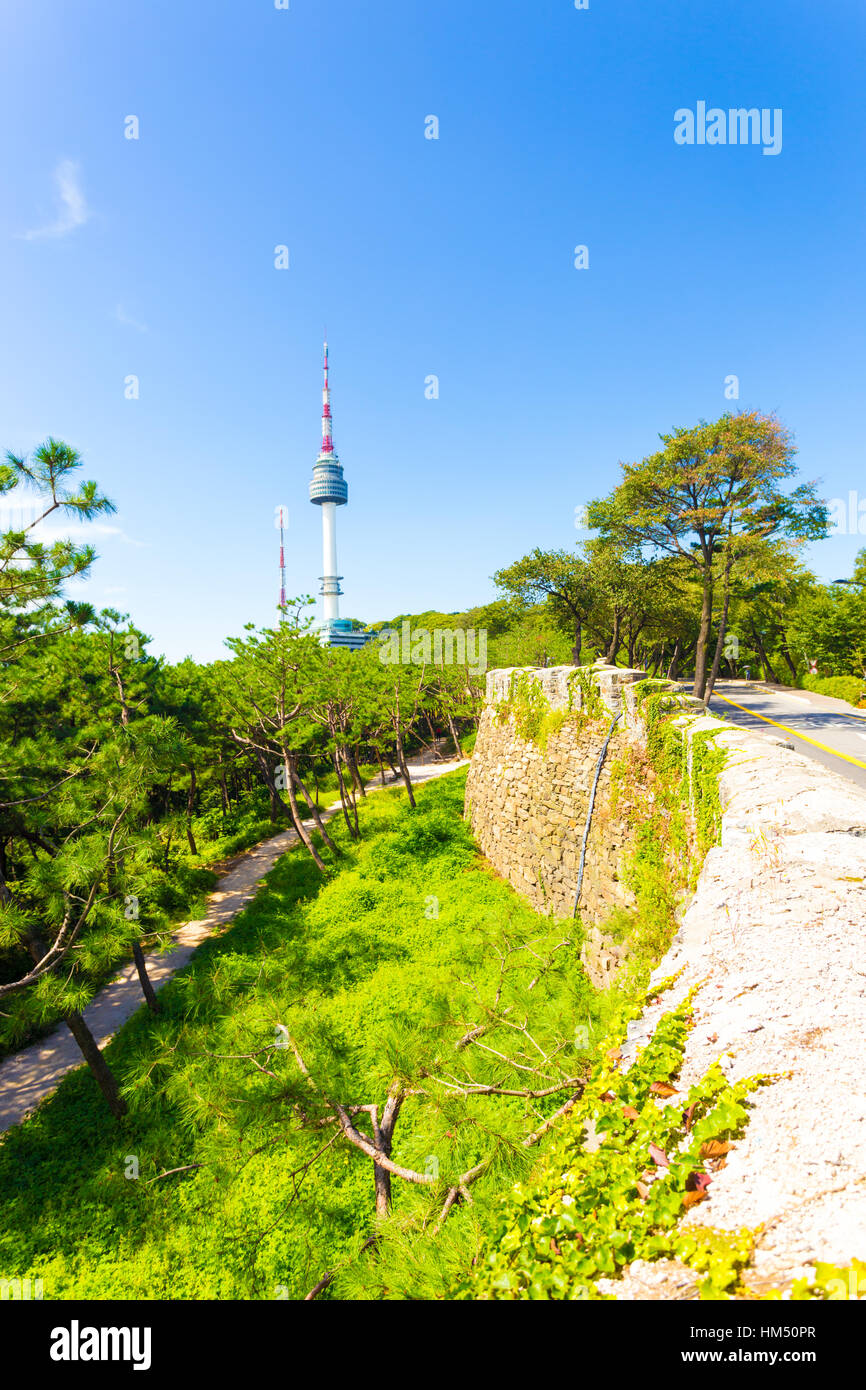 Alte Stadtmauer und Straße im Vordergrund laufen YTN Seoul Tower broadcast Antenne am Namsan Berg an einem klaren, blauen Himmel Tag Stockfoto